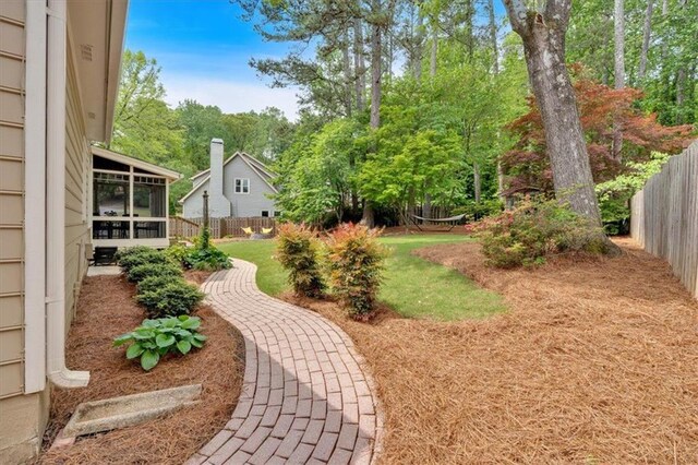 view of yard featuring fence and a sunroom