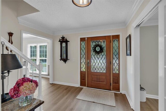 entrance foyer with baseboards, light wood-style flooring, and a textured ceiling