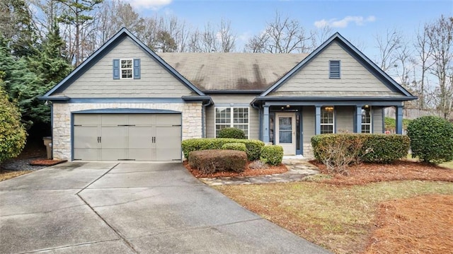 view of front facade featuring concrete driveway, an attached garage, and stone siding