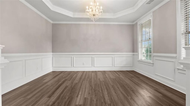 unfurnished room with a notable chandelier, crown molding, a raised ceiling, and dark wood-type flooring