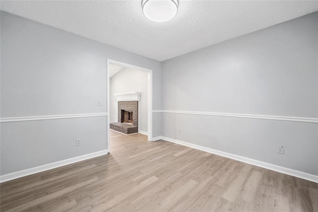 3232 Valley View St, Powder Springs, GA 30127 - unfurnished living room with wood finished floors, a textured ceiling, and a fireplace