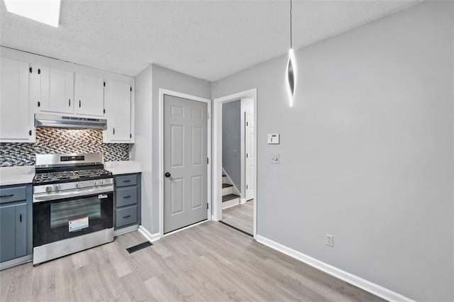 3232 Valley View St, Powder Springs, GA 30127 - kitchen with stainless steel gas range oven, under cabinet range hood, light wood finished floors, a textured ceiling, and light countertops