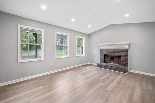 3232 Valley View St, Powder Springs, GA 30127 - unfurnished living room featuring wood finished floors, a brick fireplace, vaulted ceiling, recessed lighting, and a textured ceiling