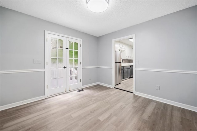 3232 Valley View St, Powder Springs, GA 30127 - spare room featuring french doors, wood finished floors, and a textured ceiling