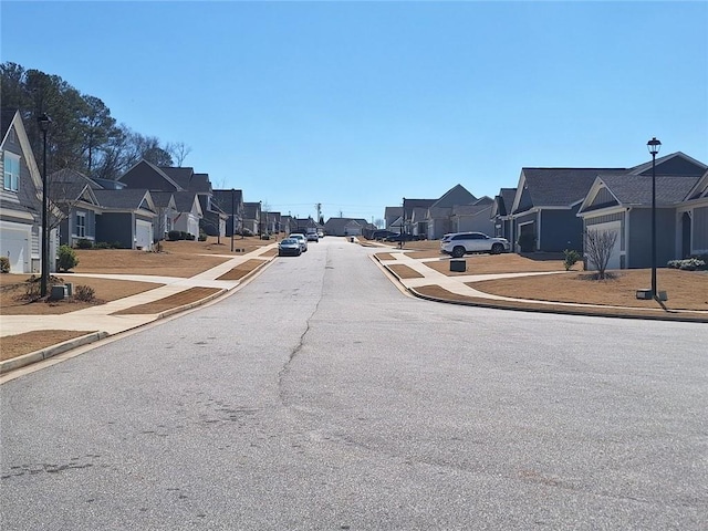 view of street featuring sidewalks, curbs, a residential view, and street lighting