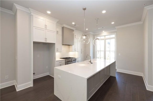 kitchen with dark hardwood / wood-style flooring, premium range hood, a center island with sink, white cabinetry, and hanging light fixtures