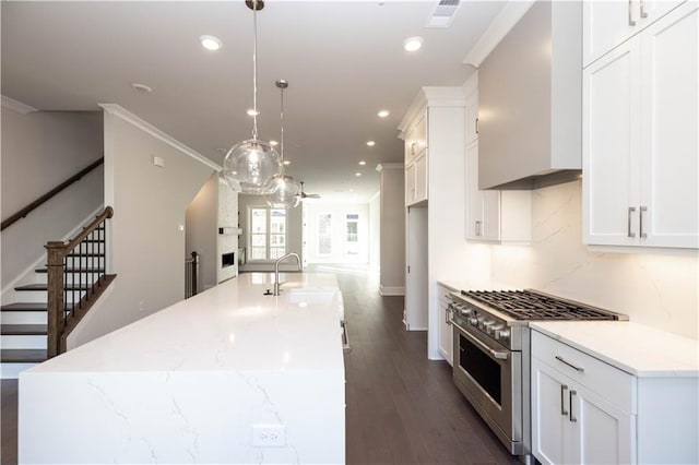 kitchen with pendant lighting, sink, dark hardwood / wood-style floors, high end stove, and light stone counters