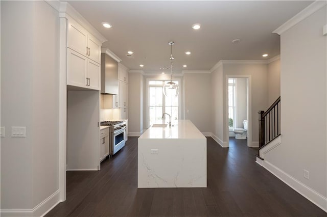 kitchen featuring white cabinetry, hanging light fixtures, dark hardwood / wood-style flooring, an island with sink, and high end stainless steel range