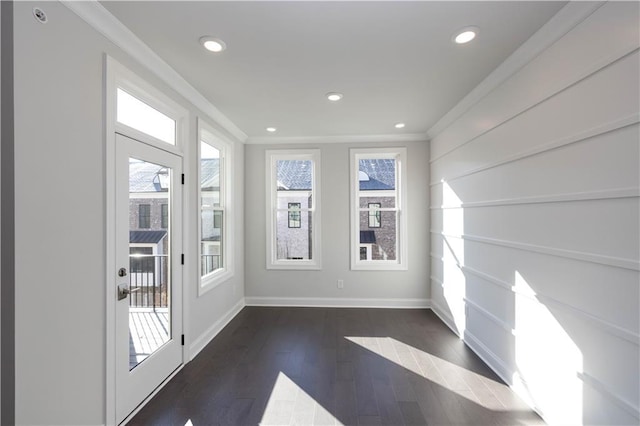 interior space featuring a healthy amount of sunlight, dark hardwood / wood-style floors, and ornamental molding