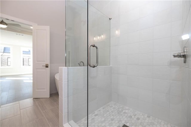 bathroom featuring tile patterned flooring, ceiling fan, and a shower with shower door