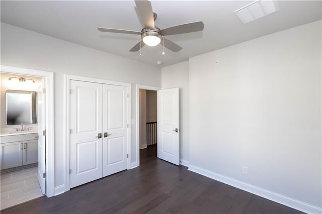 unfurnished bedroom with connected bathroom, ceiling fan, sink, and dark wood-type flooring