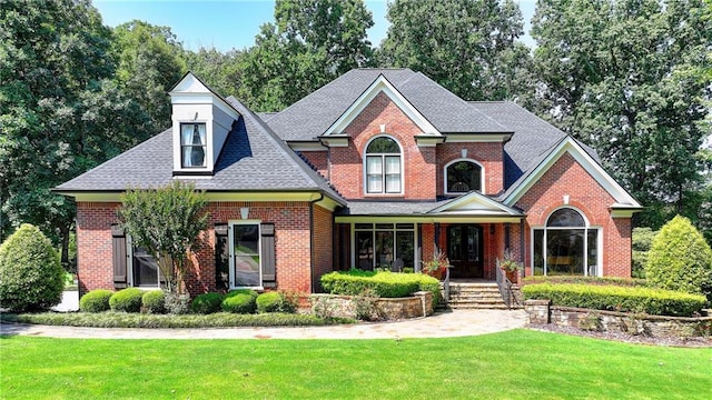 10020 Normandy Ln, Suwanee, GA 30024 - view of front of home with a front yard, brick siding, a shingled roof, and a porch