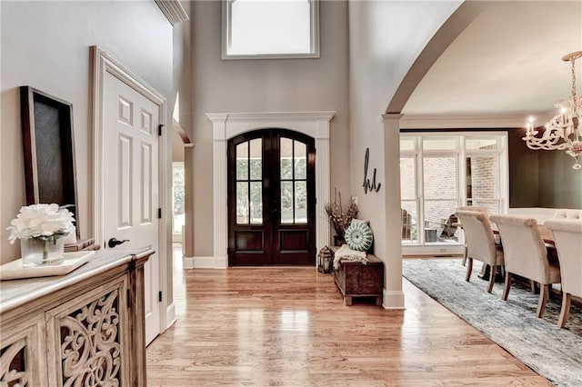10020 Normandy Ln, Suwanee, GA 30024 - foyer with arched walkways, a chandelier, light wood finished floors, and a towering ceiling