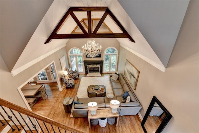 10020 Normandy Ln, Suwanee, GA 30024 - living area with wood finished floors, a chandelier, vaulted ceiling, and a glass covered fireplace