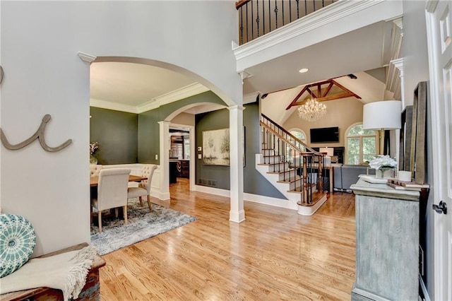 10020 Normandy Ln, Suwanee, GA 30024 - entrance foyer with stairs, wood finished floors, arched walkways, a chandelier, and crown molding