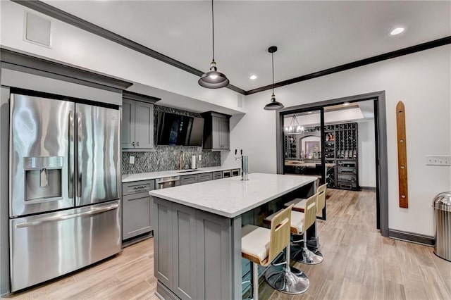 10020 Normandy Ln, Suwanee, GA 30024 - kitchen with appliances with stainless steel finishes, gray cabinets, crown molding, a breakfast bar, and backsplash
