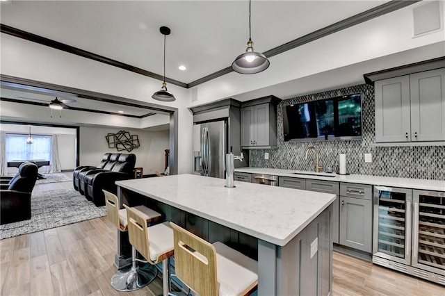 10020 Normandy Ln, Suwanee, GA 30024 - kitchen with wine cooler, stainless steel fridge with ice dispenser, ornamental molding, gray cabinetry, and open floor plan