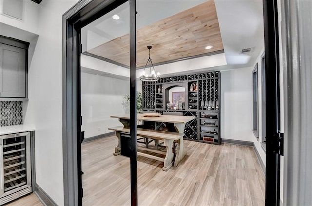 10020 Normandy Ln, Suwanee, GA 30024 - wine area with wine cooler, a chandelier, light wood-type flooring, a raised ceiling, and recessed lighting