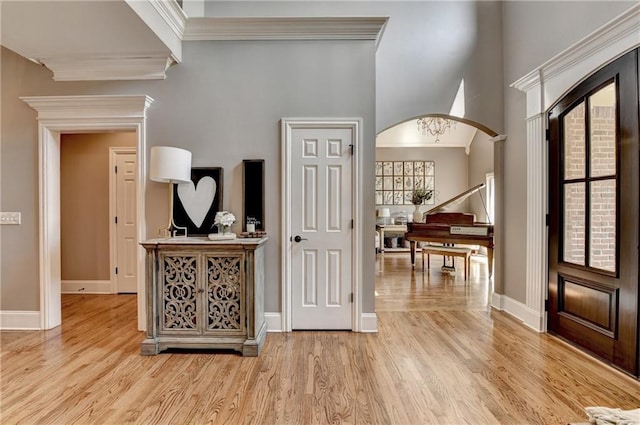 10020 Normandy Ln, Suwanee, GA 30024 - foyer with arched walkways, light wood-style floors, ornamental molding, and a high ceiling