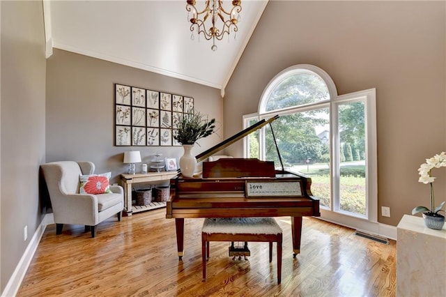 10020 Normandy Ln, Suwanee, GA 30024 - sitting room with wood finished floors, crown molding, a chandelier, and high vaulted ceiling