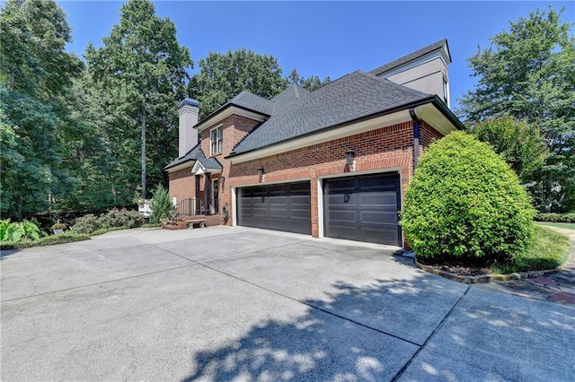 10020 Normandy Ln, Suwanee, GA 30024 - view of home's exterior featuring brick siding, concrete driveway, a garage, a chimney, and a shingled roof