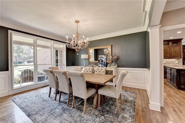 10020 Normandy Ln, Suwanee, GA 30024 - dining area featuring a chandelier, ornamental molding, wainscoting, a decorative wall, and light wood finished floors