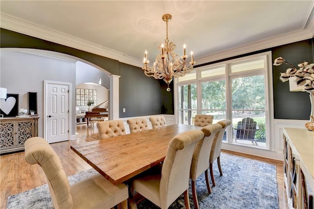 10020 Normandy Ln, Suwanee, GA 30024 - dining space with arched walkways, a chandelier, crown molding, and light wood-style floors