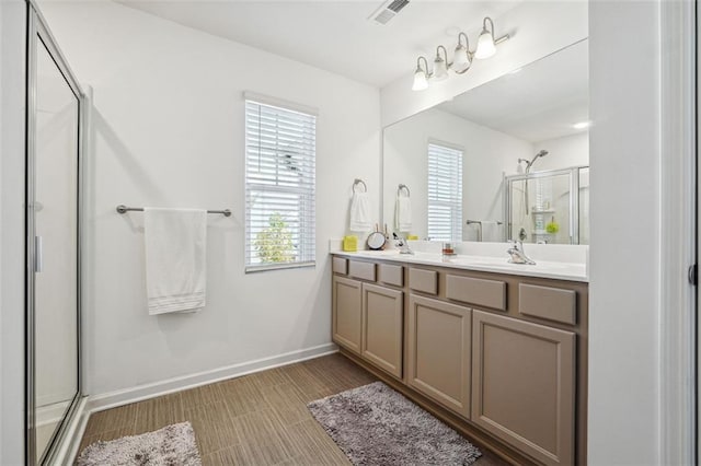 bathroom with a shower with shower door and vanity