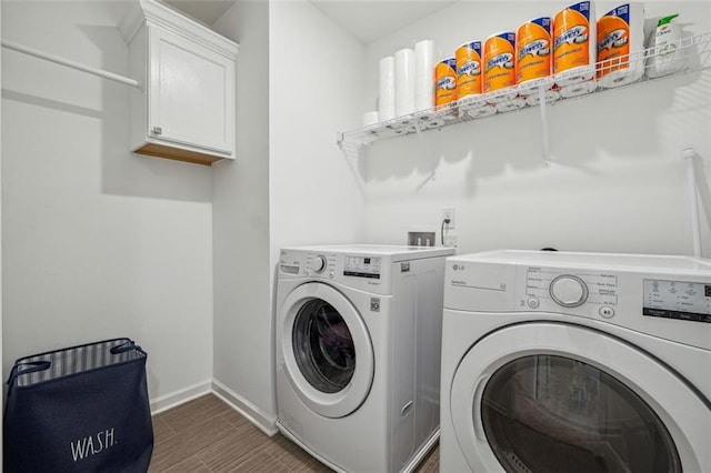 clothes washing area with washing machine and dryer and cabinets