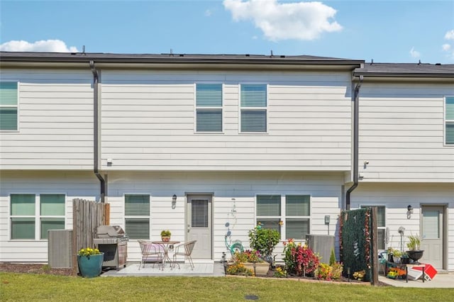 back of house featuring a lawn and a patio area