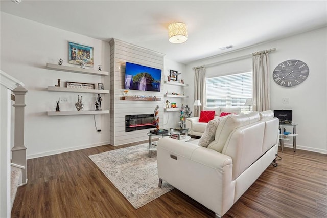 living room with a fireplace and dark hardwood / wood-style flooring