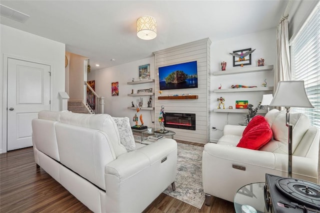 living room featuring a large fireplace and dark hardwood / wood-style floors