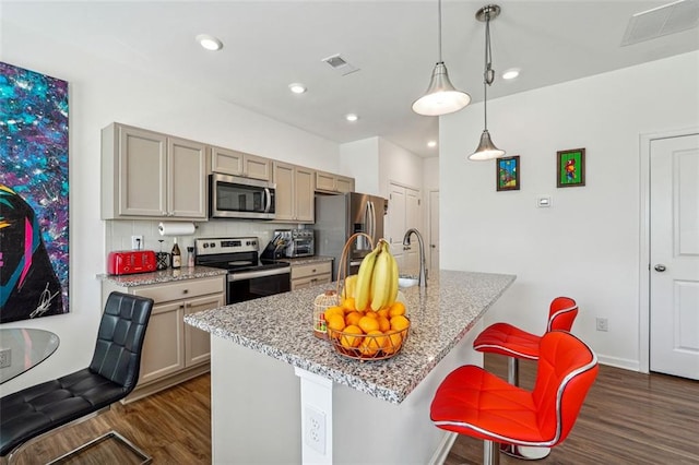 kitchen featuring light stone countertops, stainless steel appliances, pendant lighting, and dark wood-type flooring