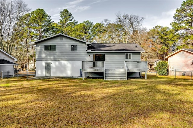 rear view of house featuring a lawn and a wooden deck