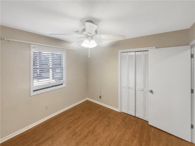 unfurnished bedroom featuring hardwood / wood-style floors, a closet, and ceiling fan