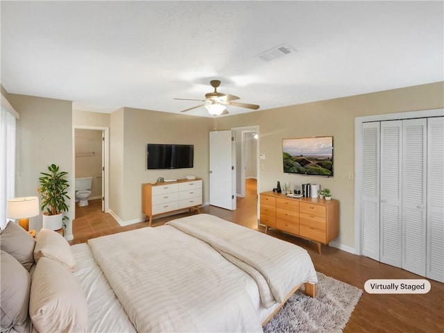 bedroom with ceiling fan, ensuite bath, and a closet