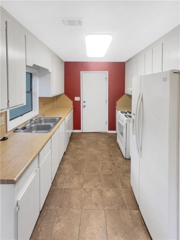 kitchen featuring white cabinetry, sink, and white appliances