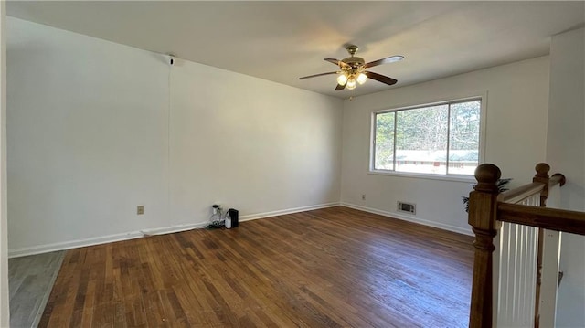 empty room featuring ceiling fan, wood finished floors, visible vents, and baseboards