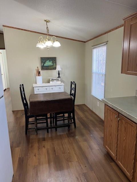 dining space featuring dark hardwood / wood-style flooring, ornamental molding, and a chandelier