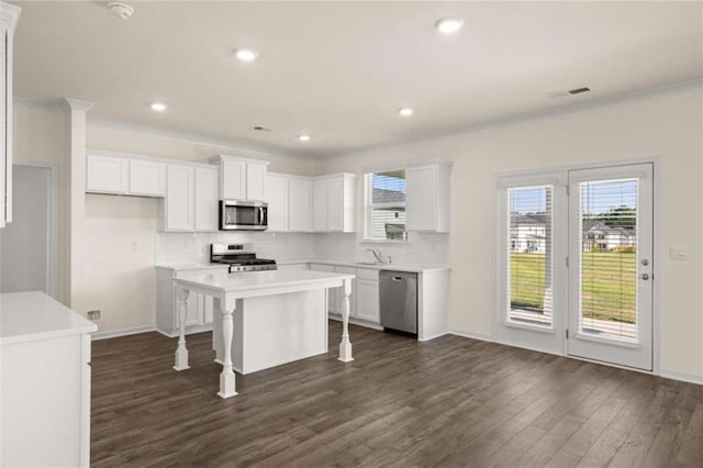 kitchen featuring stainless steel appliances, white cabinets, visible vents, and dark wood-style flooring