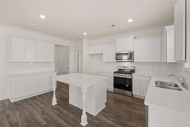 kitchen with dark wood-style flooring, crown molding, visible vents, appliances with stainless steel finishes, and a sink