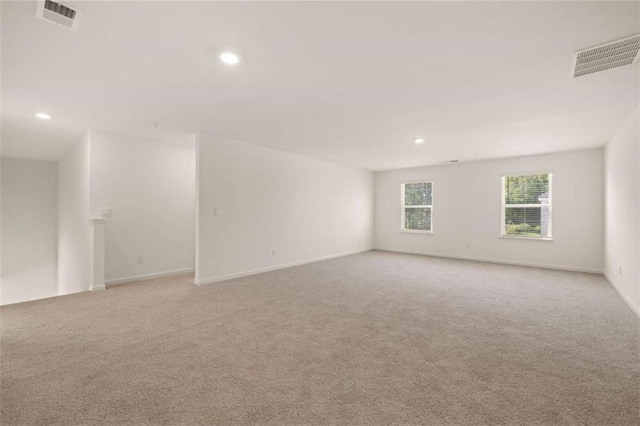 unfurnished room with light carpet, baseboards, visible vents, and recessed lighting