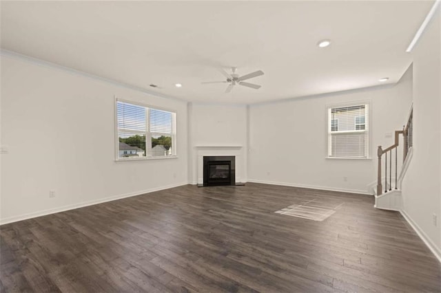 unfurnished living room with dark wood-style flooring, a fireplace with flush hearth, a ceiling fan, baseboards, and stairs