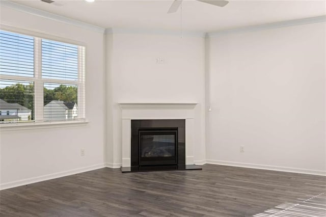 unfurnished living room featuring baseboards, dark wood finished floors, crown molding, and a glass covered fireplace