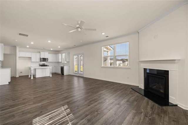 unfurnished living room featuring baseboards, visible vents, dark wood-style flooring, and recessed lighting