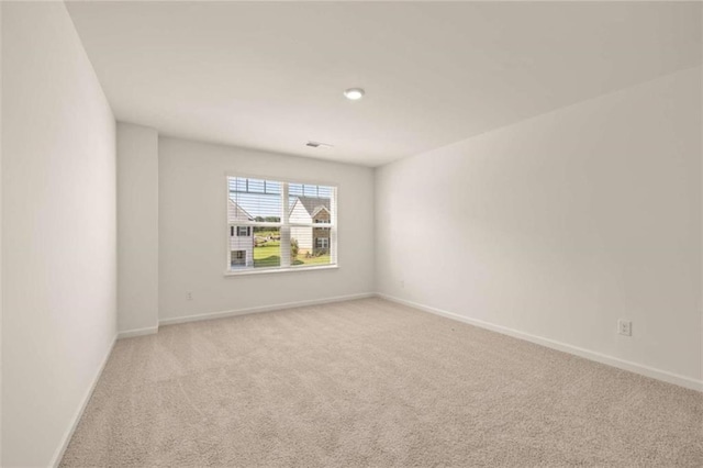 unfurnished room featuring light colored carpet and baseboards