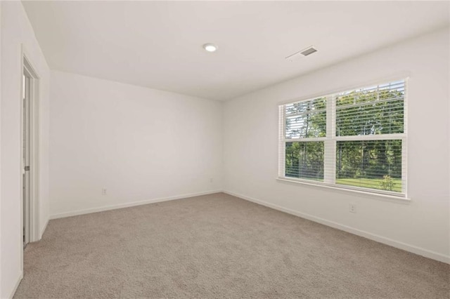 spare room featuring light carpet, recessed lighting, visible vents, and baseboards