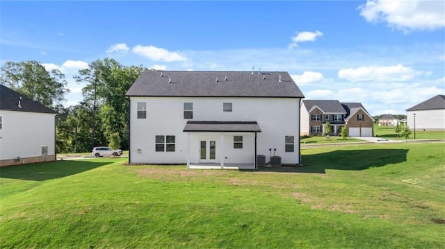 back of property with a patio area, central AC, and a lawn