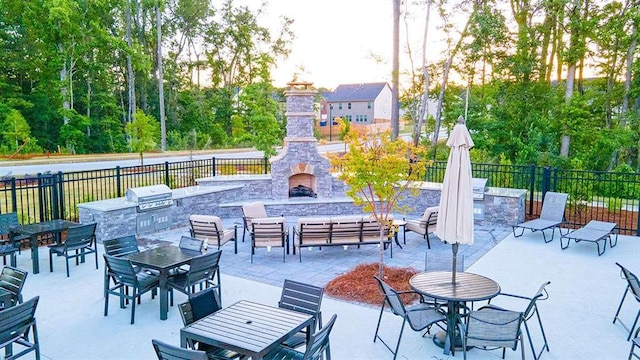 view of patio with area for grilling, a grill, fence, an outdoor living space with a fireplace, and outdoor dining space