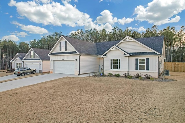 view of front of home with a garage, a front lawn, and central AC unit